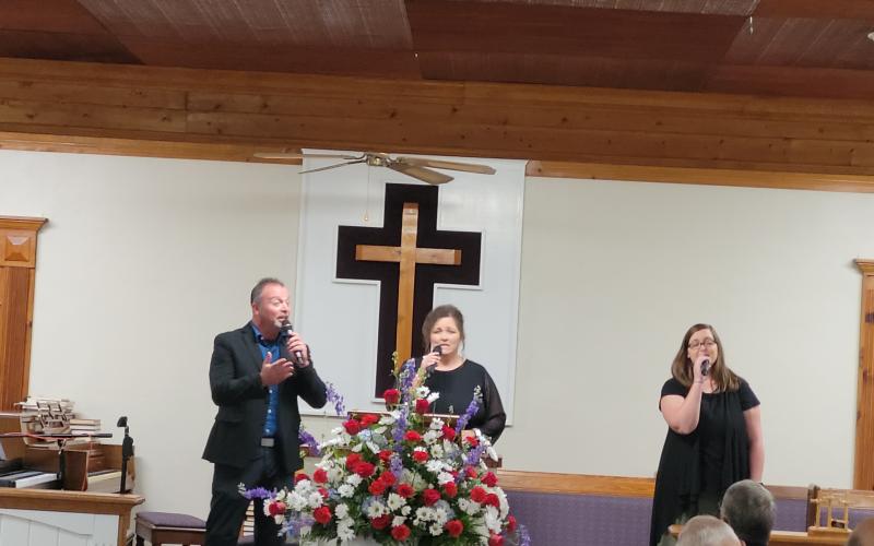 Megan Broome/The Clayton Tribune. Echoes of Mercy from Anderson, S.C., made up of Brian, Laura and Ashley Latham, sing worship music as the guest musicians for Bethel Baptist Church’s 130th Anniversary celebration July 17.