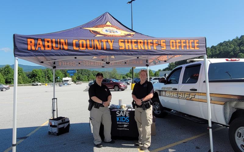 Megan Broome/The Clayton Tribune. Deputies Lisa Thompson, coordinator for Safe Kids Rabun County, and Ana Contreras conduct Car Seat Safety Checks and check seats for expiration, safety recalls, proper fit and proper installation. The technicians also educated the public about vehicle safety during the event at Walmart July 23.