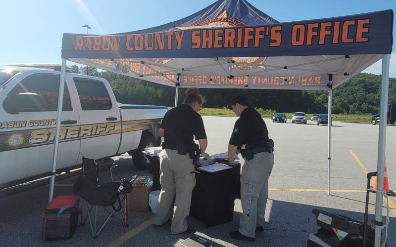 Megan Broome/The Clayton Tribune. Deputies Lisa Thompson, coordinator for Safe Kids Rabun County, and Ana Contreras conduct Car Seat Safety Checks and check seats for expiration, safety recalls, proper fit and proper installation. The technicians also educated the public about vehicle safety during the event at Walmart July 23.
