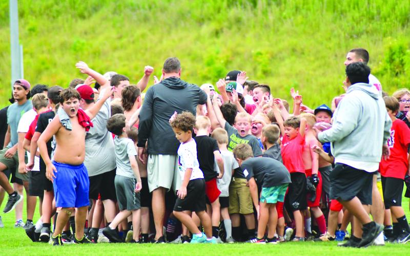 Enoch Autry/The Çlayton Tribune. With RCHS head coach Michael Davis (center) leading the group, the football campers react to an evening of fun on the field.