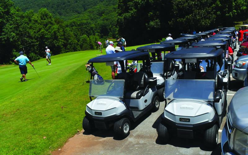 Enoch Autry/The Clayton Tribune. Golf carts line up to head out onto the course for the shotgun start on July 22 for the tournament. Thirty-six two-person teams played.