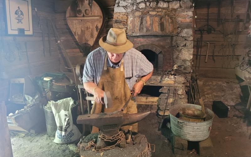 Megan Broome/The Clayton Tribune. Joe Williams demonstrates blacksmithing at the Foxfire Museum Heritage Days event in Mountain City July 8 and 9.