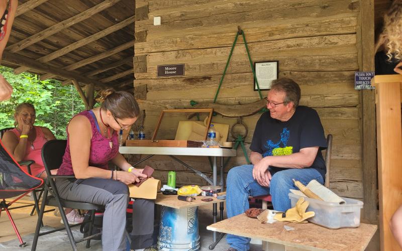 Megan Broome/The Clayton Tribune. Jim Enloe demonstrates Flintknapping to Shay Aument during the Foxfire Heritage Days event.