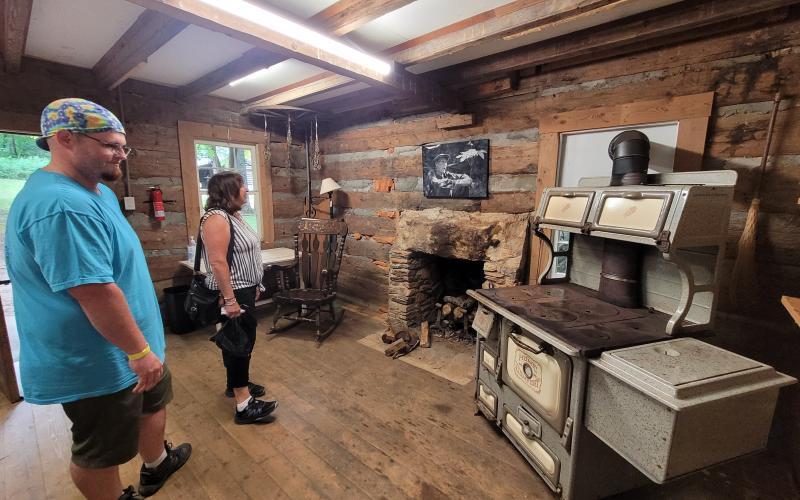 Megan Broome/The Clayton Tribune. Travis Chattin and Linda Chattin check out the exhibits at the Foxfire Museum during the Heritage Days Festival July 9.