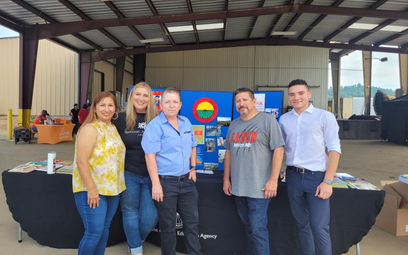 Megan Broome/The Clayton Tribune. Paula Macedo, Migrant Program Liaison for Gainesville City Schools, Vanesa Sarazua with Hispanic Alliance, Evelyn Arevalo, Region 1 Migrant Education Program Recruiter for the Georgia Department of Education, Roberto Aguilar, Migrant SSP for Rabun County Schools, and Rodney Santana, volunteer from Hall County, participate in the Hispanic Information and Health Fair on July 22 at the Osage Farms packing house in Rabun Gap.