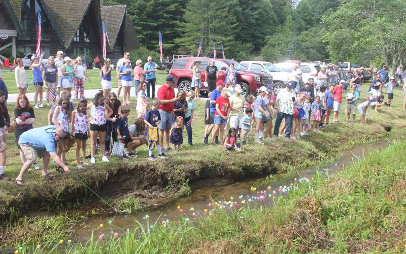 Megan Broome/The Clayton Tribune. Hundreds of spectators and children cheered on their rubber ducks during the Rubber Duck Race in Sky Valley July 2. Franklin Watson, age 3, was the lucky duck who took home First Place in the race with duck number 13. He won a bubble machine as his prize.
