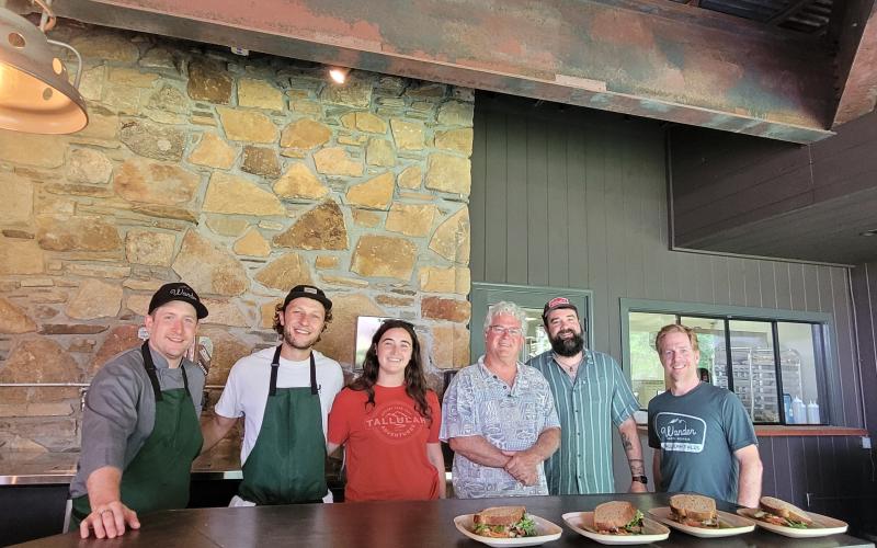 Megan Broome/The Clayton Tribune. Chef Ryne Brown, General Manager of Food Service for Tallulah Adventures, left; Kyle Jerome, Food Service Coordinator for Tallulah Adventures; Spencer Turk, operations and events manager for Tallulah Adventures; Bill Turk, owner of Tallulah Adventures; Josh Brown-co-owner of Wander North Georgia; and Jake Scott-co-owner of Wander North Georgia open Tallulah Adventures and the second location of Wander North Georgia to members of the public.
