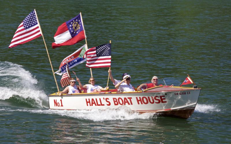 Photo courtesy of KA Hamdy-Swink. The “Hall’s No. 1” 1957 Chris Craft Sportsman 20’ owned by Thad and Darlene Warren sails down Lake Rabun during the Wooden Boat Parade.