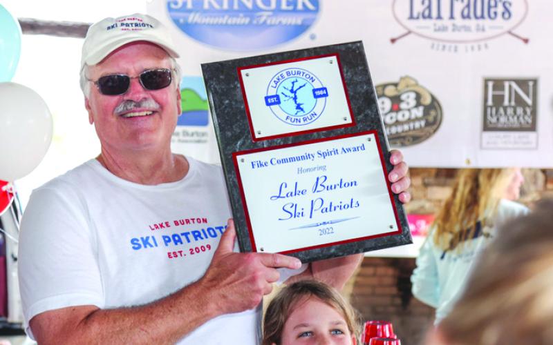 Photography courtesy Melissa Elzey. Lee Penland displays the plaque  bestowed to the Lake Burton Ski Patriots by the run organizers.