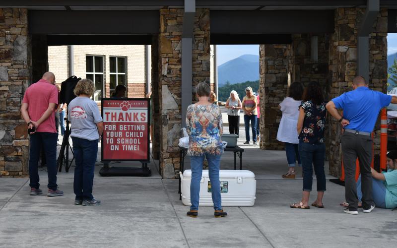 Enoch Autry/The Clayton Tribune. Those who attended on July 30 pray outside the primary school.
