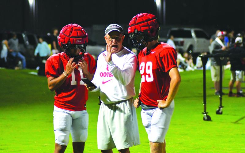 Enoch Autry/The Clayton Tribune. Coach CJ Stockel directs players as it approaches 1 a.m. on Aug. 1 at the Proving Ground practice field. In the background, fans line the sidelines at the high school to watch the 2022 version of the Wildcats.