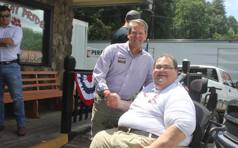 Megan Broome/The Clayton Tribune. Ed Henderson, secretary of the Rabun County Republican Party, shakes hands with Gov. Brian Kemp at The Rusty Bike Café during a meet-and-greet in Clayton Aug. 4.