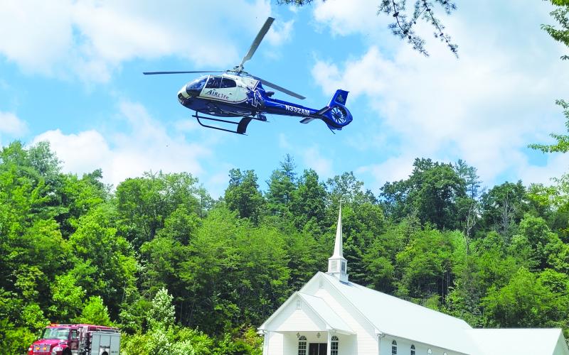 Megan Broome/The Clayton Tribune. Emergency personnel work the LZ site located at Pleasant Hill Missionary Baptist Church as the patient is transported by AIRLife following a single motorcycle crash on Warwoman Road Aug. 13.