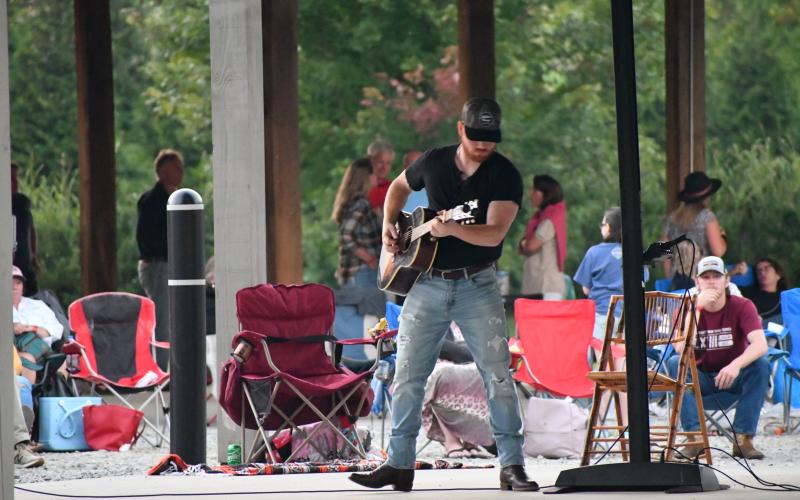 Megan Broome/The Clayton Tribune. Jeb Gipson warms up before he performs in front of crowds of people during a music concert hosted by the Clayton Merchants and Business Association (CMBA).