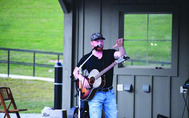 Megan Broome/The Clayton Tribune. Jeb Gipson performs in front of crowds of people during a music concert hosted by the Clayton Merchants and Business Association (CMBA).
