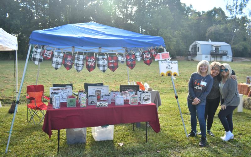 Megan Broome/The Clayton Tribune. Paula Mann, Elaine Mann, and Samantha Mann from Sunshine Design by Paula were set up at the Tiger Corn Festival last weekend.