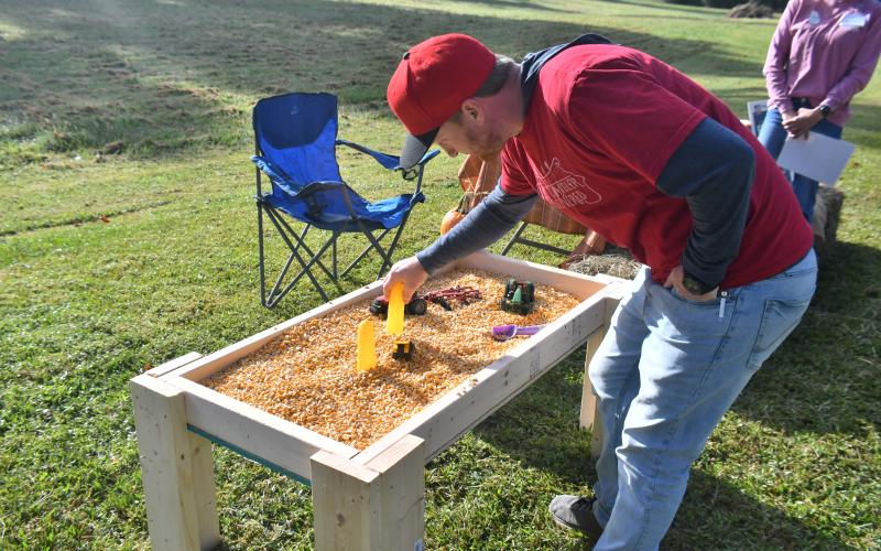 Megan Broome/The Clayton Tribune. Conner Horn checks out the Farm Bureau sandbox full of corn at the Tiger Corn Festival.