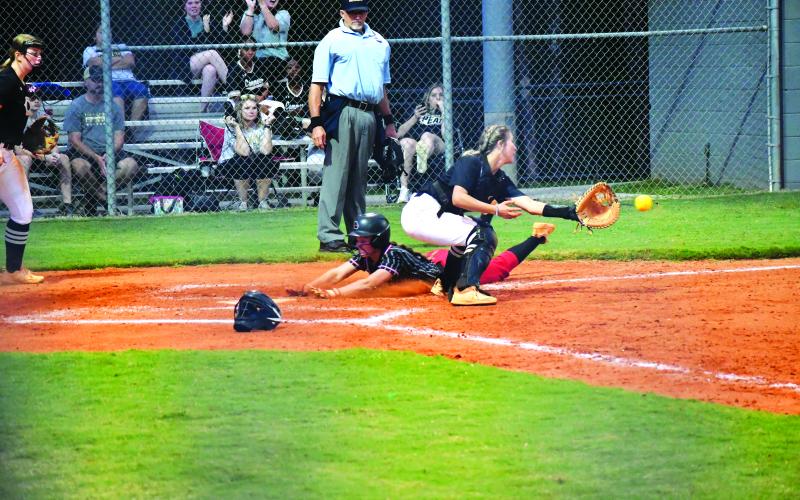 Luke Morey/The Clayton Tribune. Junior Mili Watts slides into home plate for an in the park home run.