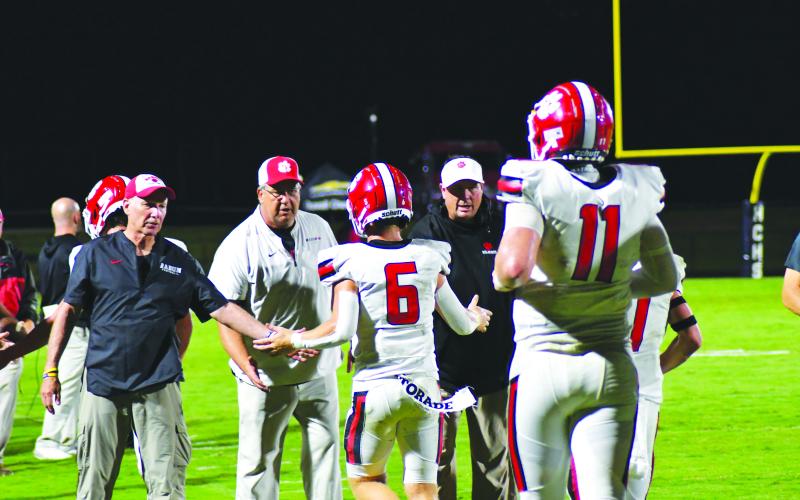 Enoch Autry/The Clayton Tribune. Senior Jaden Gibson (6) receives congratulations from the Wildcat coaching staff after catching the second of four touchdown from senior quarterback Keegan Stover (11) on Aug. 19 against Haralson County.