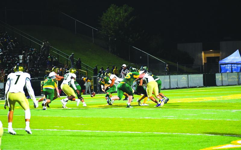 Luke Morey/The Clayton Tribune. Junior Hector Gonzalez strips quarterback Hayden Craig in the final minute of the game. Junior Gideon Herbet (#52) recovered the ball.