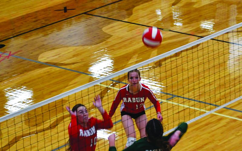 Luke Morey/The Clayton Tribune. RGNS sophomore Cathryn Carmack goes up for a kill against RCHS juniors Anna Raye Darnell and Mira Tinnefeld. The Lady Cats went 1-1 while the Eagles went 2-0.