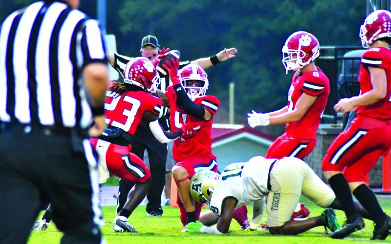 Enoch Autry/The Clayton Tribune. RCHS senior Noah Legault (middle) forced and recovered a fumble in the first quarter to set up another scoring drive. Here senior Cory Keller (right) and junior Willie Goodwyn surround Legault. A few plays earlier, Legault forced another fumble but Adairsville recovered. Before the Tigers’ loss to RCHS, Adairsville was ranked No. 10 in Class AAA