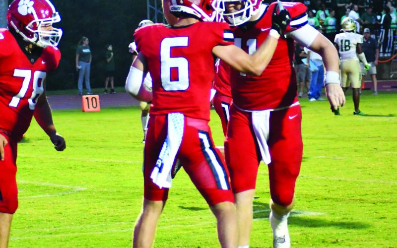 Enoch Autry/The Clayton Tribune. Senior Jaden Gibson (left) celebrates his fourth touchdown of the night with senior quarterback Keegan Stover (right) who ended with a record-setting eight passing touchdowns.