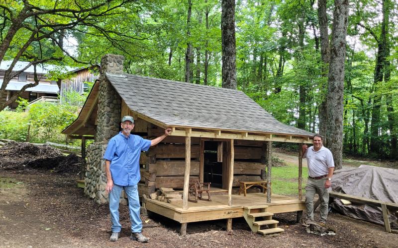 Megan Broome/The Clayton Tribune. Barry Stiles, Foxfire museum director (left) and Todd Faircloth, Foxfire executive director, showcase the miniature replica of the Warwoman Cabin as part of the new Children’s Village.