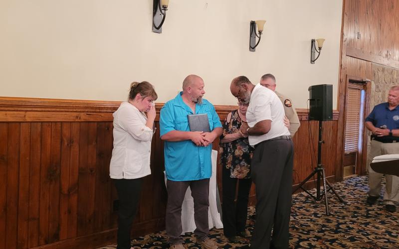 Megan Broome/The Clayton Tribune. Allen Poole, director of the Georgia Governor’s Office of Highway Safety, and Rabun County Sheriff Chad Nichols present a plaque and hug Crystal Zajdowicz, David Cross and Janet Zajdowicz, the family of Rabun County Detention Center Officer Cpl. Courtney Faith Zajdowicz, at the 31st annual Hands Across the Border event at The Dillard House Aug. 30.