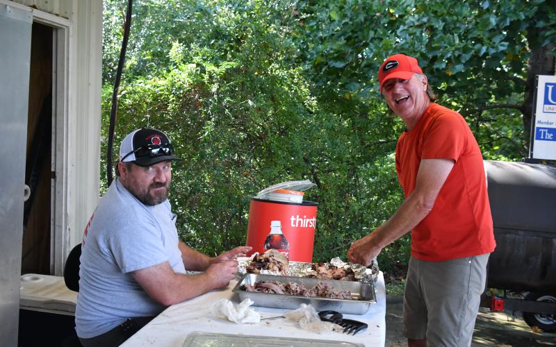Megan Broome/The Clayton Tribune. Shawn McKay, left, and Mark Nelson volunteer at the Station 12 BBQ last weekend.