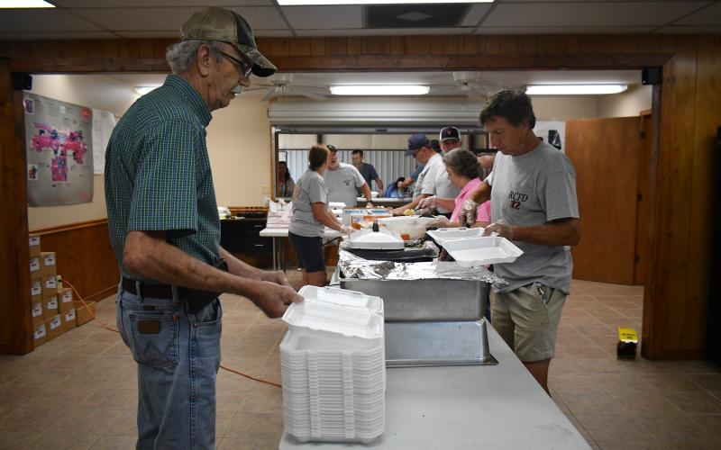 Megan Broome/The Clayton Tribune. Volunteer firefighters work at the Station 12 BBQ fundraiser last weekend.