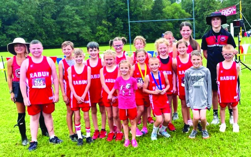 Courtesy of Ed Eidson. Head Coach Ed Eidson (right) and assistant head coach Holly Henry-Perry (left) pose with their team who all notched personal bests.