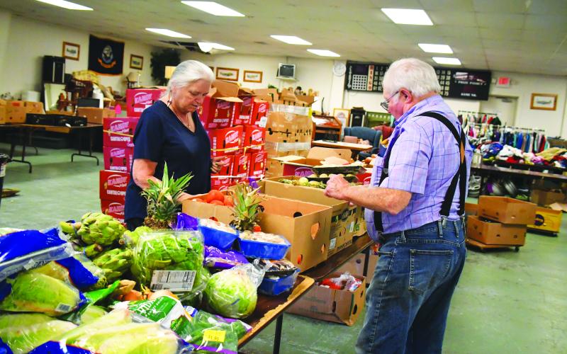 Megan Broome/The Clayton Tribune. Maryjane Webb Phillips and Carl Green volunteer at one of the Food Distributions held at the American Legion Post 220 last month. The food distribution is held every Thursday from noon-6 p.m.