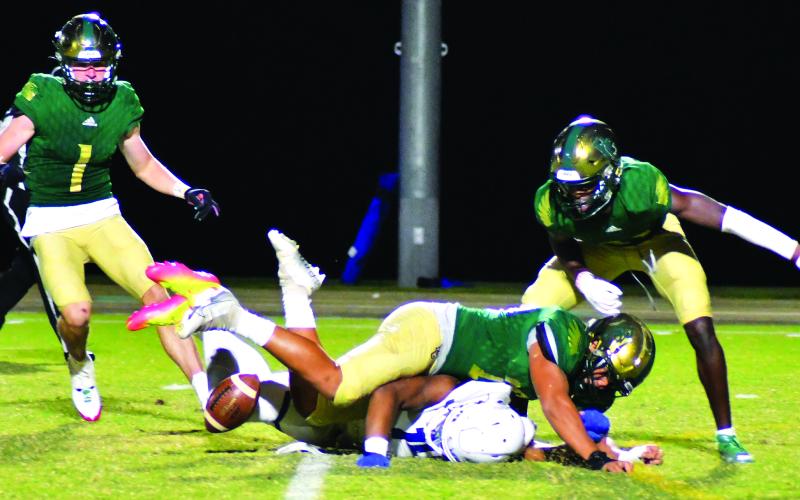 Enoch Autry/The Clayton Tribune. RGNS junior Huseyin Simsir (center) knocks the ball away from Charlotte Christian punt returner Micah Gilbert. Simsir collected the ball and then the Eagles added a field goal to push the score to 24-10.