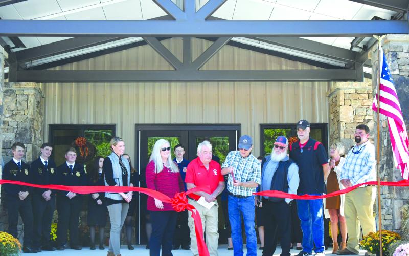 Enoch Autry/The Clayton Tribune. Rabun County Board of Education Chair and retired RCHS agriculture teacher Steve Cabe cuts the ribbon on the Rabun County Schools Agri-Science Center October 6. Pictured are Cabe with Rabun County FFA students; Board of Education Member Molly Lima; Rabun County Schools Superintendent Dr. April Childers; Rabun County Board of Education Members Wayne Stephens; Mark Beck; and Rabun County Board of Education Vice-Chair Curt Haban with Agriculture Education Instructor Clay Brown.