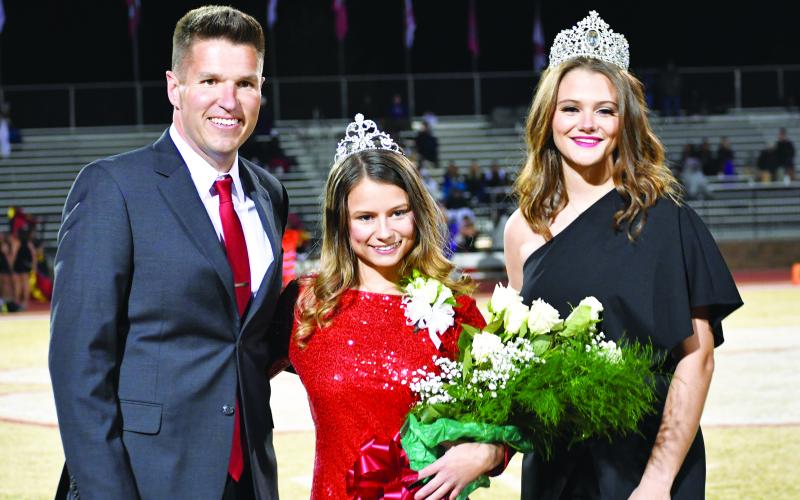 Luke Morey/The Clayton Tribune. The RCHS 2022 Homecoming Queen Rainny Patterson (center) poses with Principal Justin Spillers and 2021 Homecoming Queen Janice Steill at halftime.