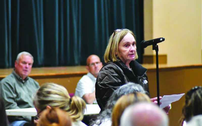 Enoch Autry/The Clayton Tribune. With commissioners Kent Woerner and Scott Crane seated behind her, Cynthia Moody addresses short-term rentals with the attendance.