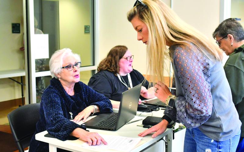 Megan Broome/The Clayton Tribune. Rabun County resident Laura Messer early votes at the Rabun County Board of Elections Office Tuesday. Poll workers Ann D’Agostino and Amanda Burrell are two of many poll workers who help voters navigate through the election process. Early voting continues through Nov. 4, with two opportunities for Saturday voting. Election Day is Tuesday, Nov. 8.
