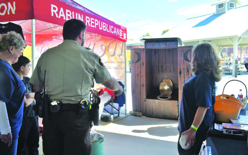 Megan Broome/The Clayton Tribune. Deputy Renalli participates in the Kiwanis Club of Rabun County toilet paper toss at the Foxfire Mountaineer Festival.