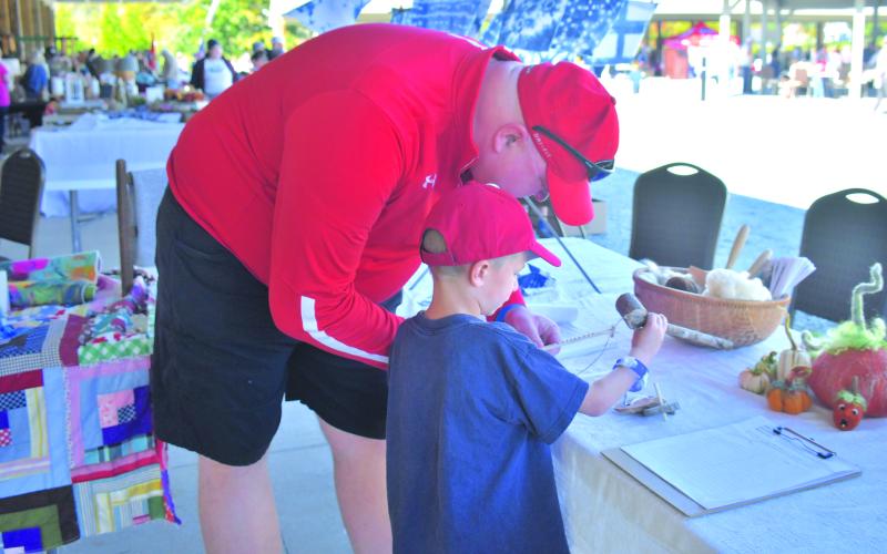 Megan Broome/The Clayton Tribune. Billy Watts and Micah Watts, 6, learn about different crafts at the Foxfire Mountaineer Festival.