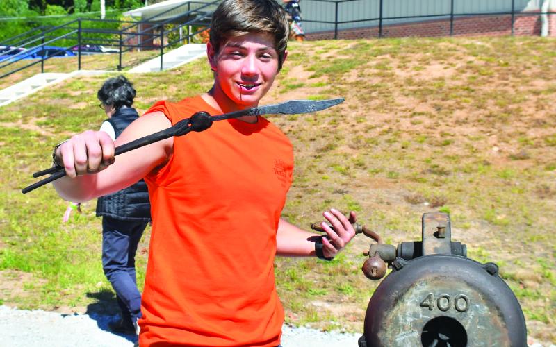 Megan Broome/The Clayton Tribune. Sam Flaherty demonstrates Blacksmithing by making a knife at the Foxfire Mountaineer Festival.