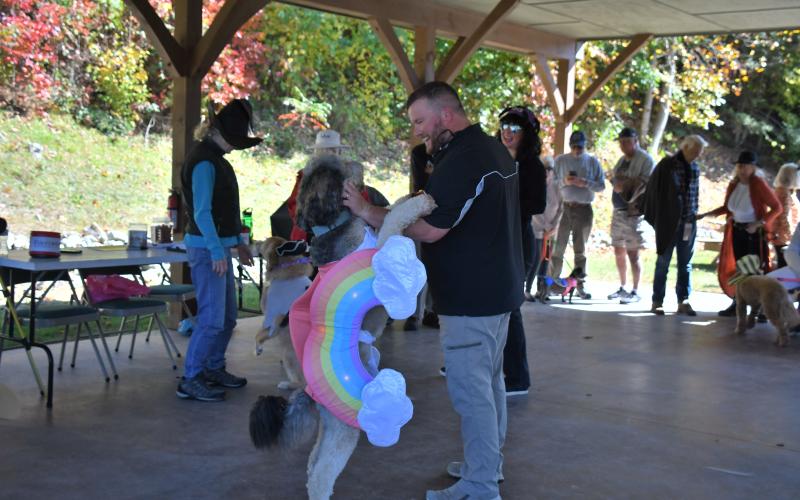 Megan Broome/The Clayton Tribune. Jonathan Judy dances and congratulates his dog “Addie” for participating in the dog costume contest at the Sky Valley Fall Fest event. “Addie” was dressed as a rainbow for Halloween.