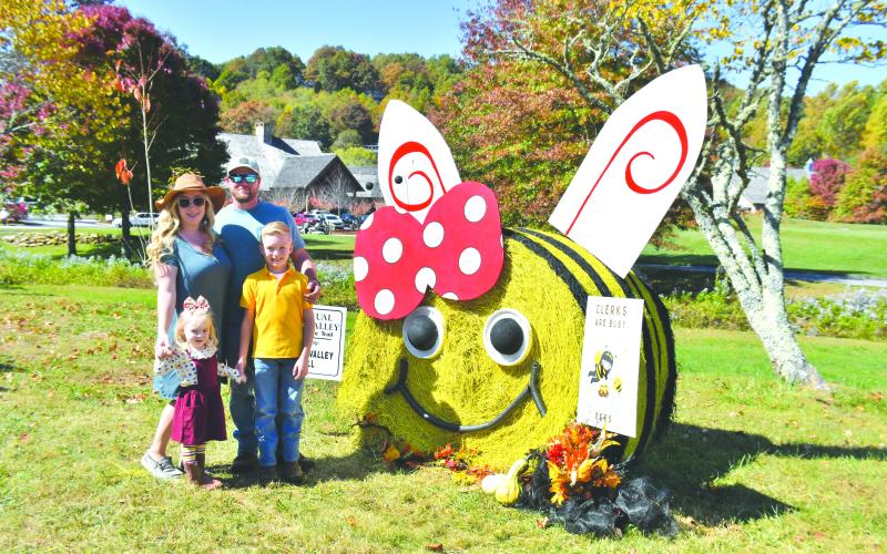 Megan Broome/The Clayton Tribune. Josh and Amber Fricks have a fun time with Jaxson, 10, and Braxlee, 3, posing in front of the Sky Valley City Hall Hay Bale decorated as a Bee during the Sky Valley Fall Fest last weekend.