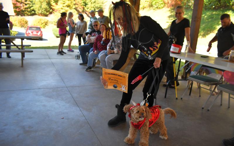 Megan Broome/The Clayton Tribune. Susan Williams poses with her dog, “Bailey,” who won Scariest Dog dressed as a Devil with horns and a pitchfork in the dog costume contest at the Sky Valley Fall Fest Saturday, Oct. 15.