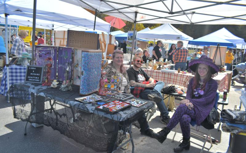 Megan Broome/The Clayton Tribune. Linda &amp; Megan’s Crafting Creations was one of many booths at the Sky Valley Fall Fest Saturday, Oct. 15. Pictured are Linda Levy, Christian Geer and Megan McClain.