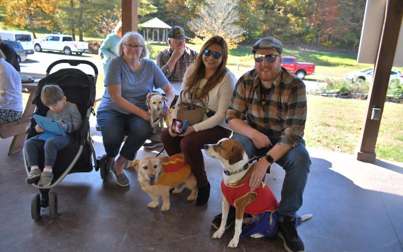 Megan Broome/The Clayton Tribune. Vincent Cheek; Vickie Cheek; Lizy Cheek; and Andrew Cheek pose with their dogs “Mr. Teddy” dressed as a shark; “Rusty” dressed as a hotdog and “Holly” dressed as a superhero at the Sky Valley Fall Fest event. The dogs were entered into the dog costume contest.