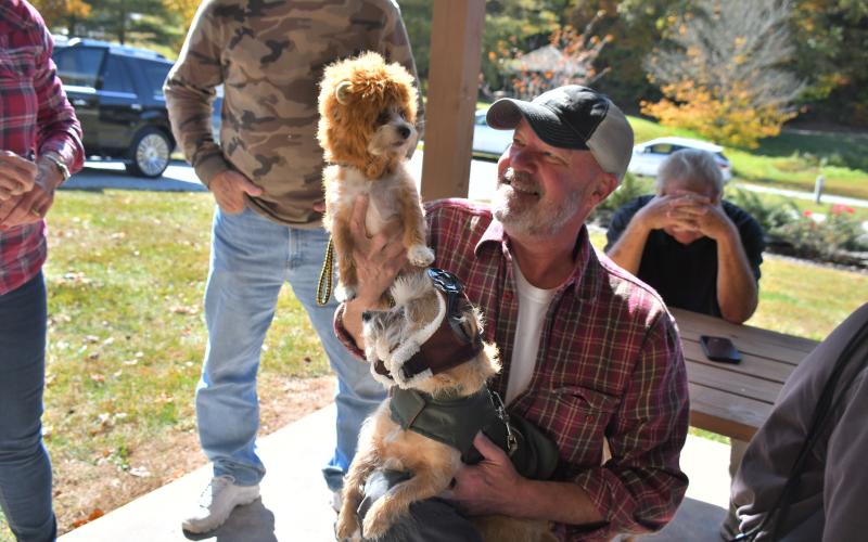 Megan Broome/The Clayton Tribune. Matt Belfi gets hugs and cuddles from his dogs “Opie” dressed as a pilot and “Daisy” dressed as a lion. “Daisy” won the category of Smallest Dog in the dog costume contest.