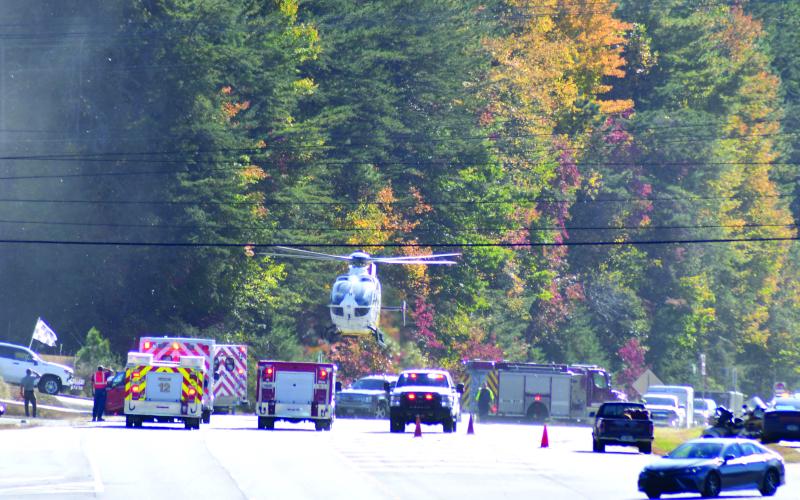 Enoch Autry/The Clayton Tribune. A helicopter lands on Georgia 15 at Seed Tick Road in Clayton Oct. 21 and emergency personnel work the scene following a crash involving a vehicle and motorcycle.