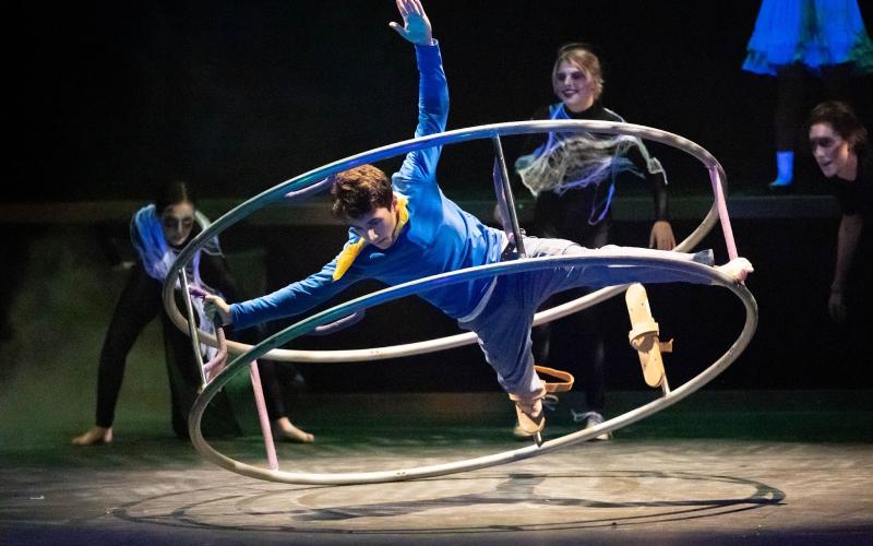 Photo courtesy Megan Morris/Rabun Gap-Nachoochee School. Cyrus Manoogian’24 of Rabun Gap, as Brian Dunning in Cirque Fantôme performs on the German wheel. Pictured in background, from left, are Juliette Teutsch ’24 of Demorest, Zoey Townsend ’23 of Cullowhee, N.C., and Parker Stribling’24 of Sautee Nacoochee, Ga.
