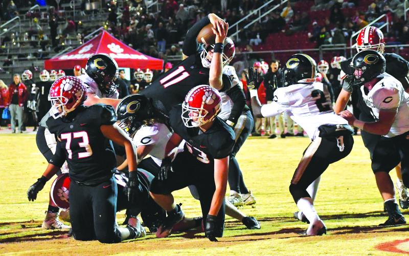 Luke Morey/The Clayton Tribune. Wildcat senior Keegan Stover leans across the line on a quarterback keeper for a touchdown to put Rabun County up 21-14. The Wildcats would win the game 27-22 to claim a ninth consecutive region title. The state playoffs begin on Nov. 11.